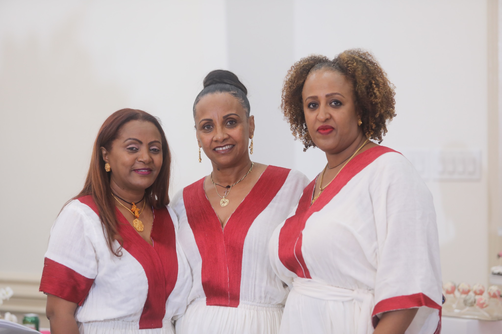 Three women celebrating together in traditional attire