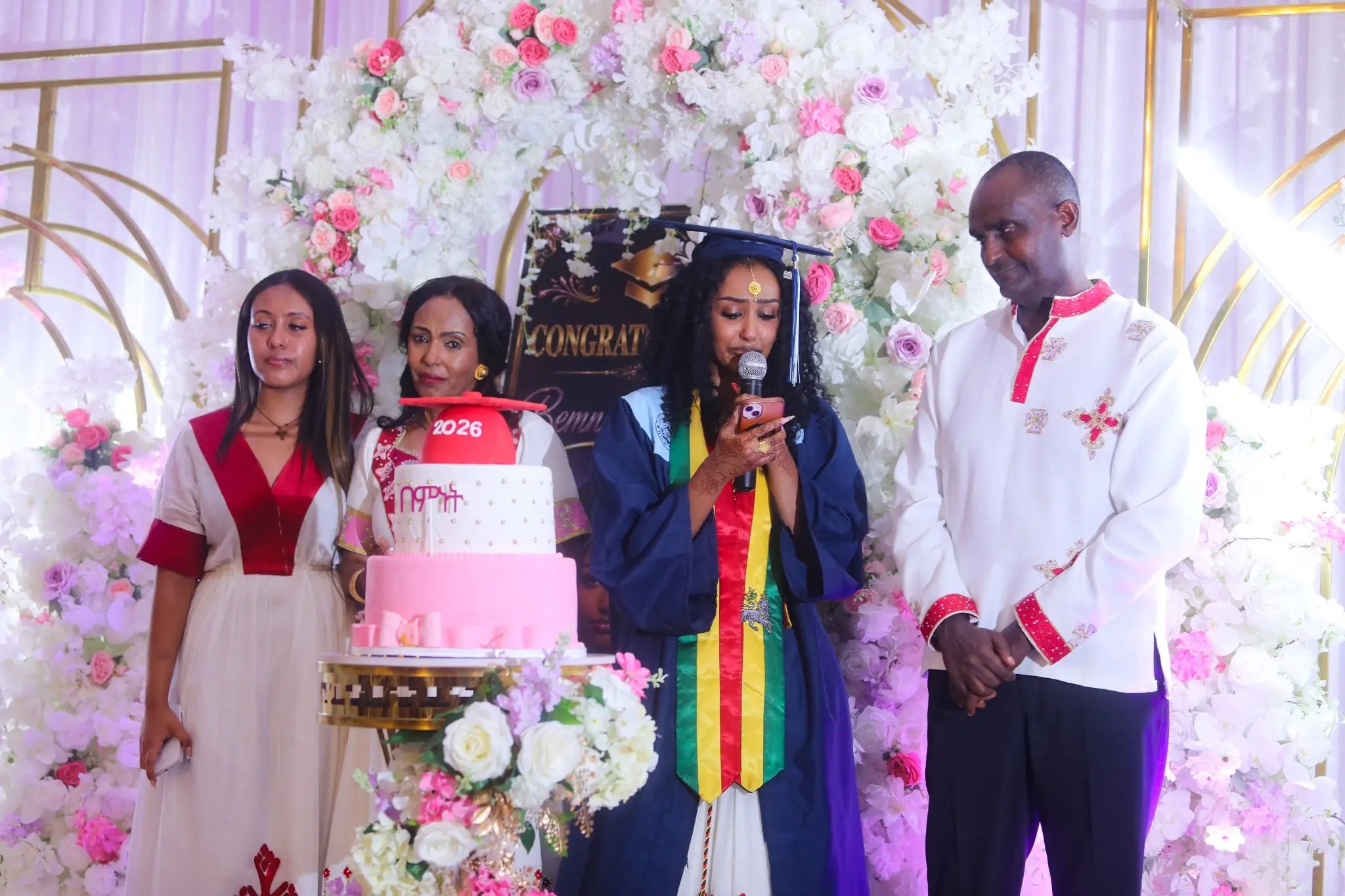 Graduate speaking with family beside her